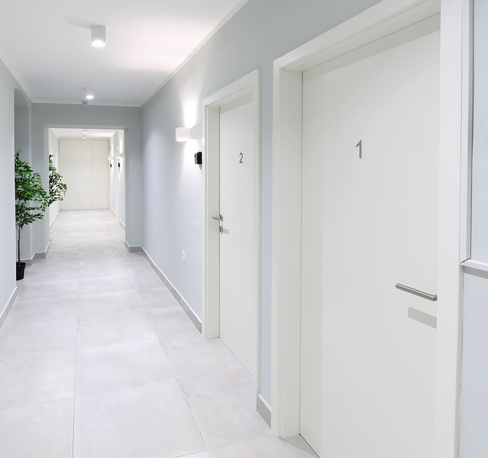 Hall way of modern building with doors and elevator at end of hall